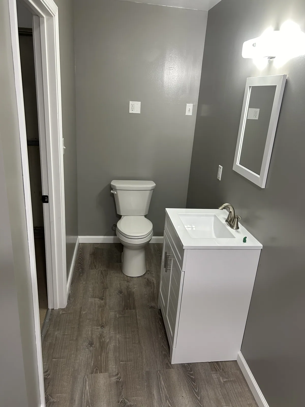 Completed bathroom with new flooring, vanity and toilet