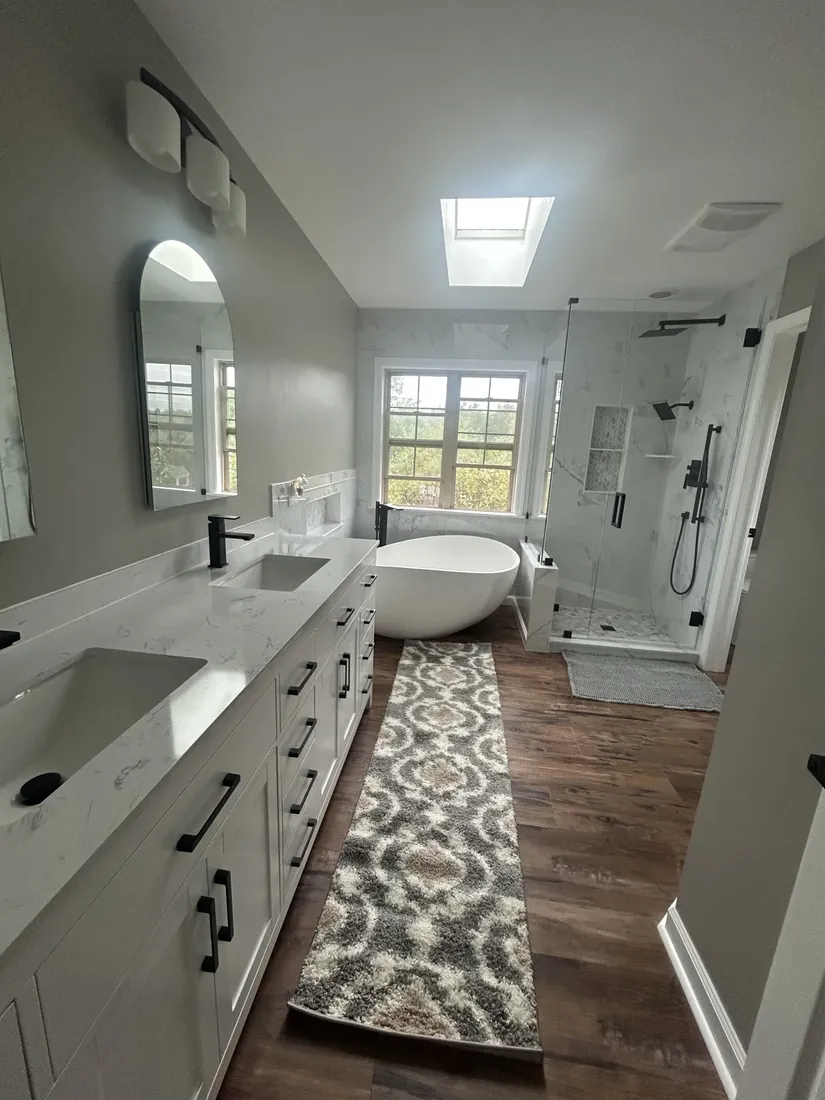 Renovated primary bathroom with a double vanity, soaking tub and marble shower