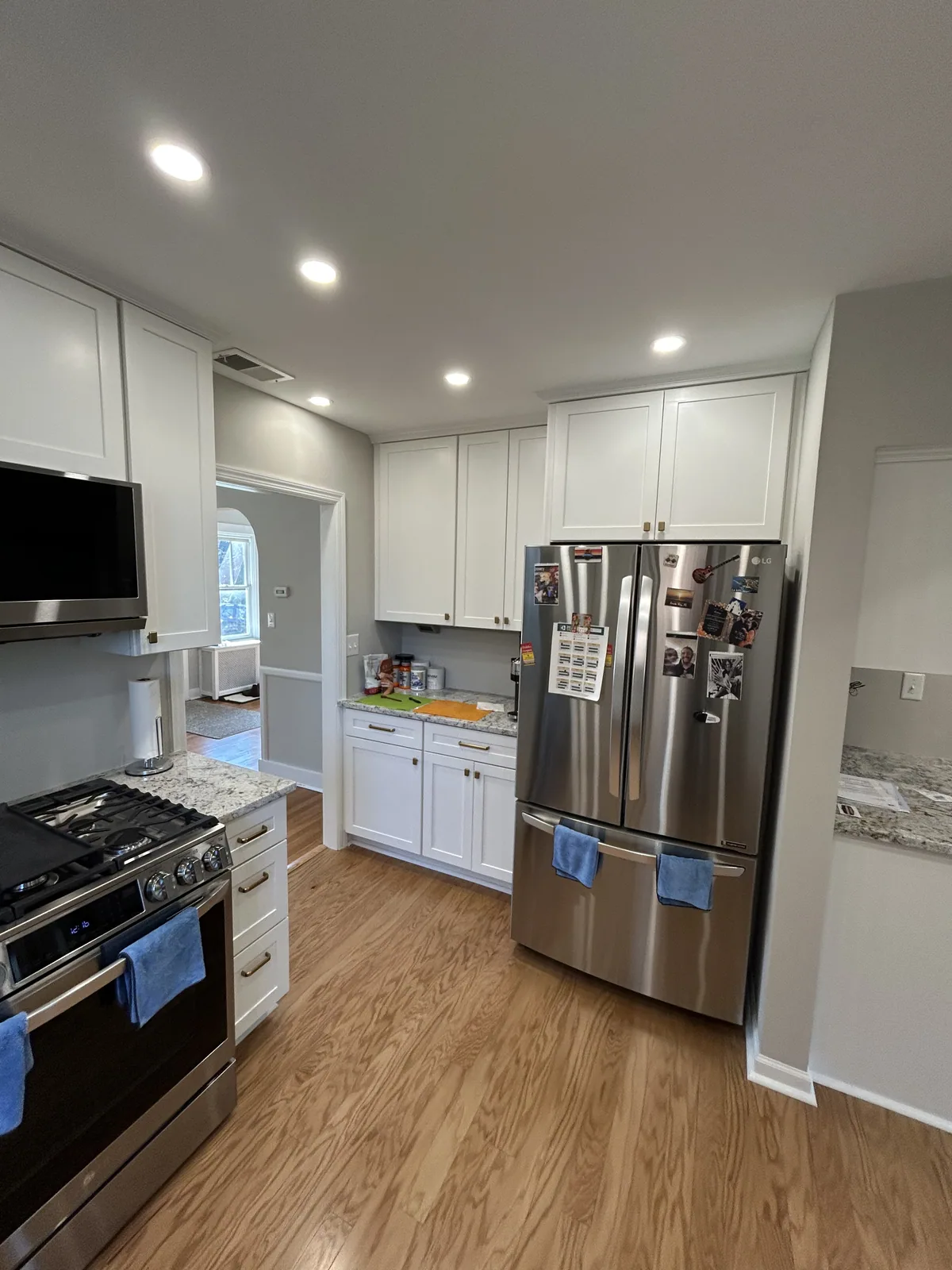 Renovated kitchen with an island, white cabinets and new flooring